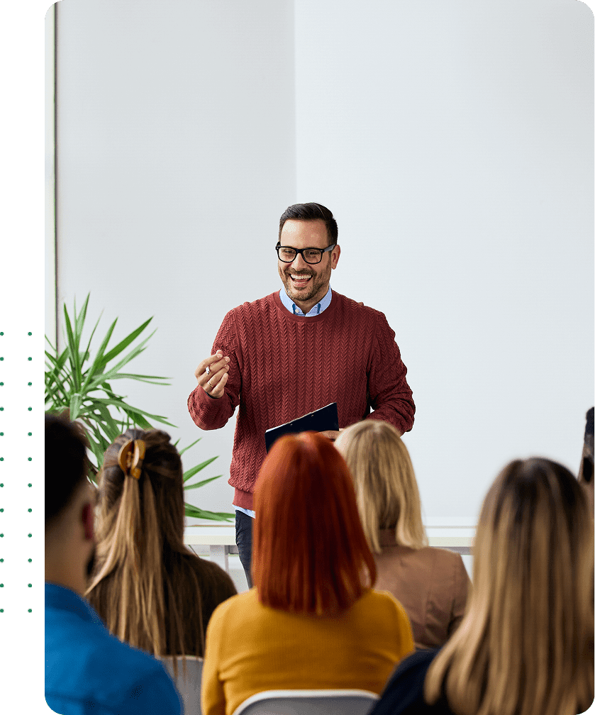 Man speaking to an attentive classroom audience.